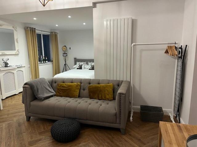 ein Wohnzimmer mit einem Sofa vor einem Bett in der Unterkunft The Old Stable in Cottingham