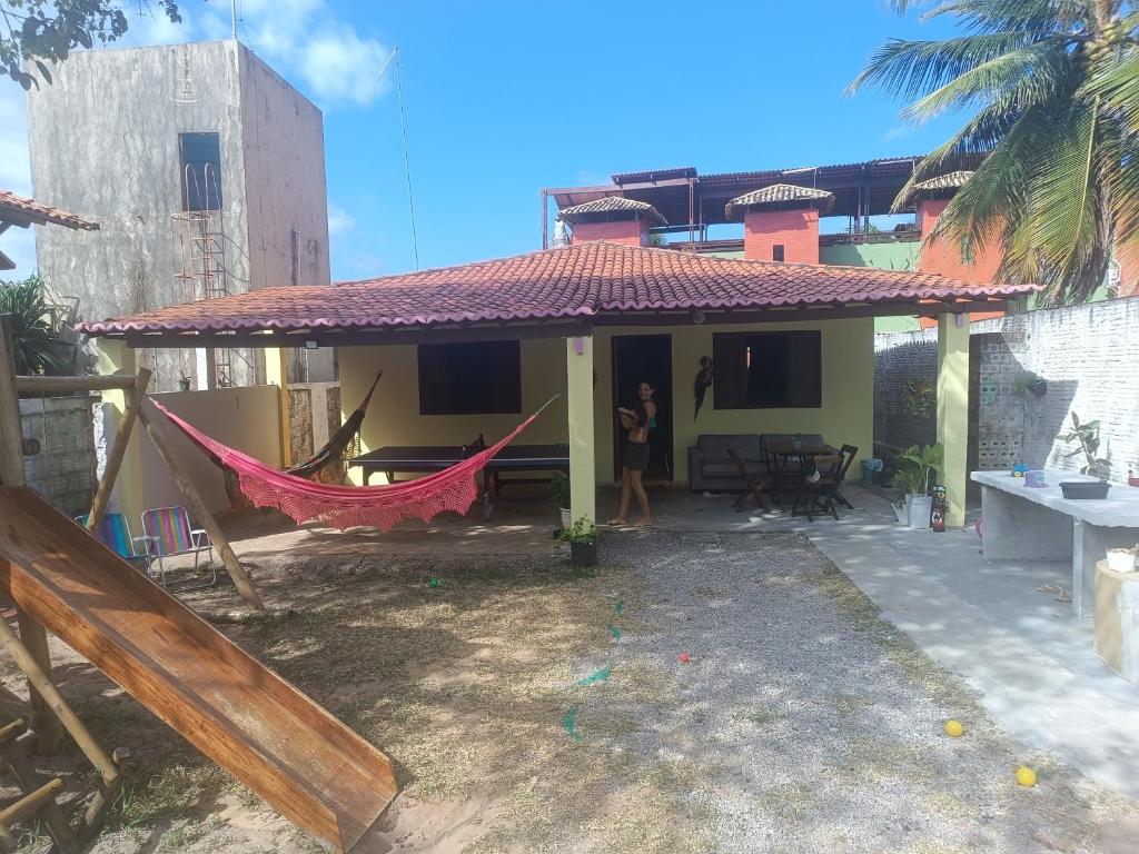 a house with a hammock in front of it at Sol guest house in Pipa