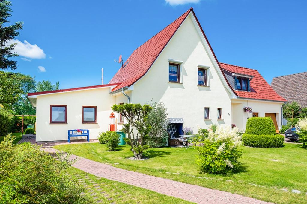 a white house with a red roof at Ferienhaus Heideweg in Zingst