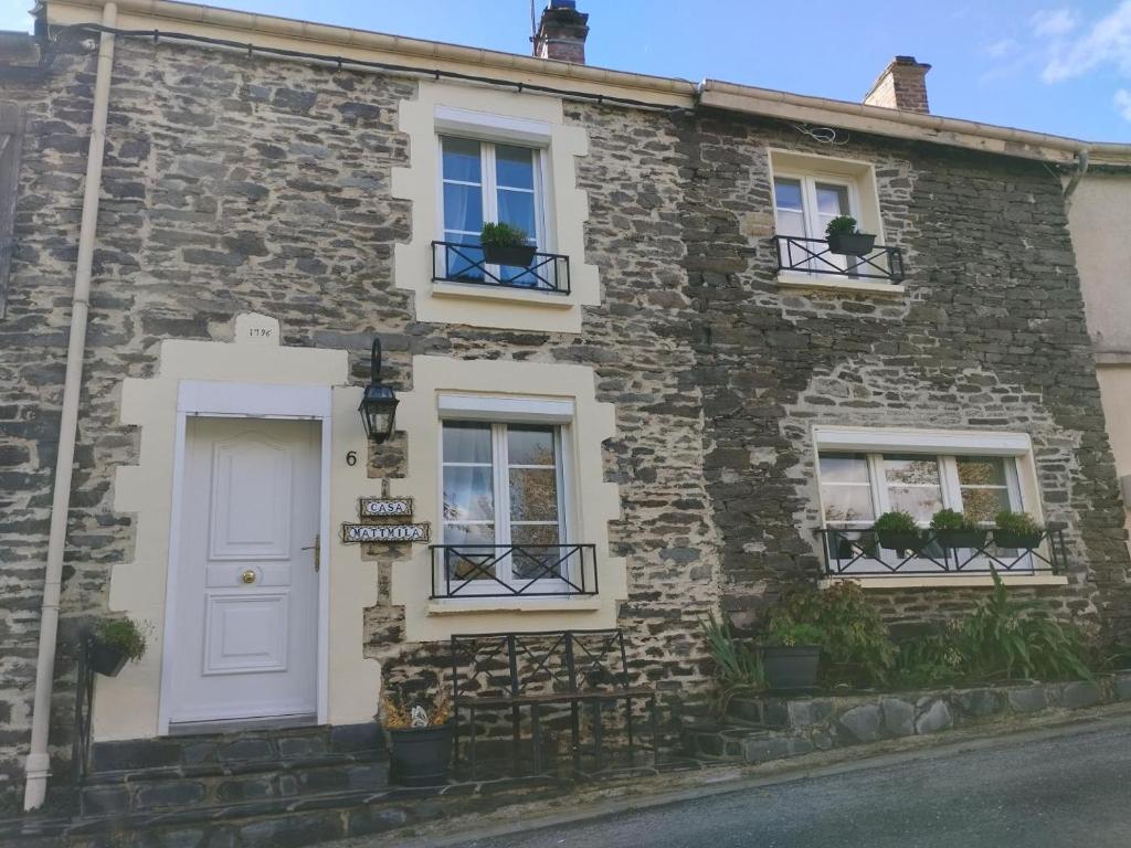 a stone house with a white door and windows at Casa mattmila in Haulmé
