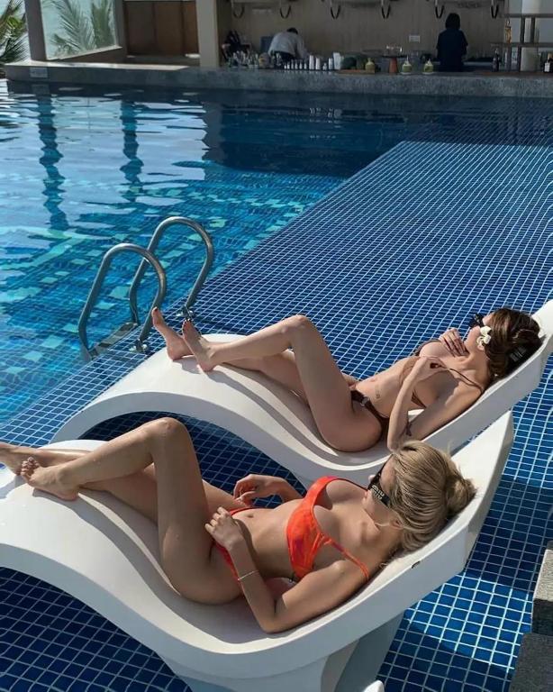 two women laying on rafts in a swimming pool at Apec Mandala Wyndham ChamBay Mui Ne - LT in Mui Ne