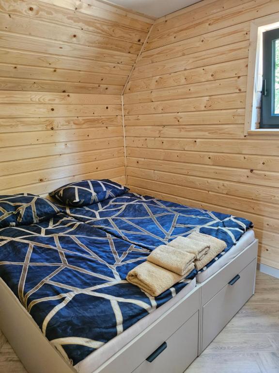 a bedroom with a bed in a wooden wall at Barn&Haus-Stodoły Widokowe in Zubrzyca Dolna