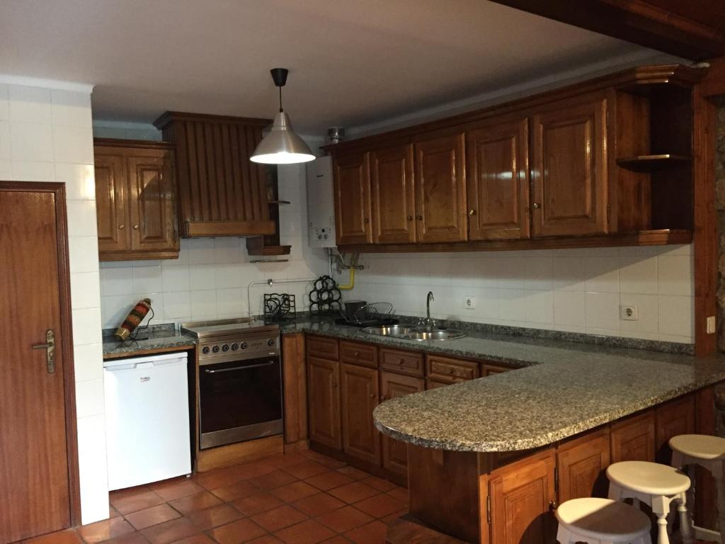 - une cuisine avec des placards en bois et un comptoir dans l'établissement Casinha das Cortes, à Vila Nova de Cerveira