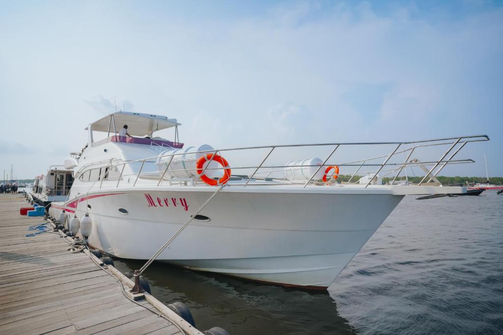a white boat is docked at a dock at Wanderlust Travel in Perean