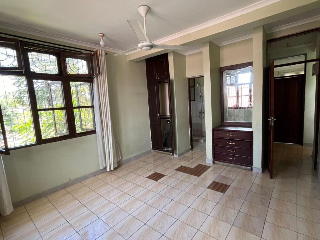 达累斯萨拉姆Home的空房设有吊扇和窗户。