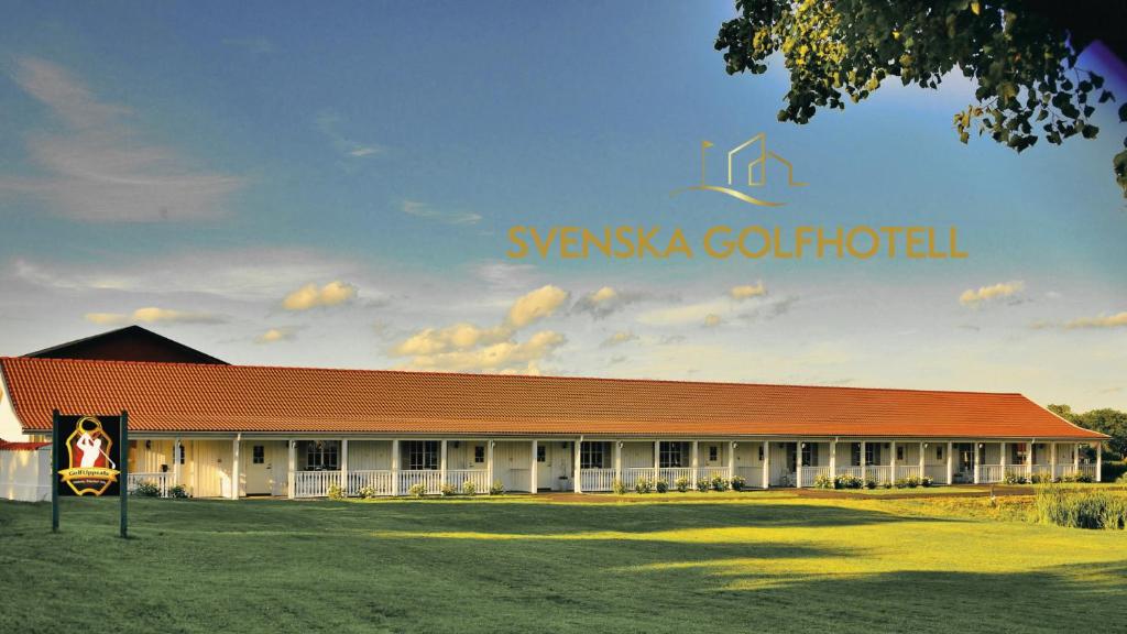 a large building with a red roof on a field at Söderby Lodge in Uppsala