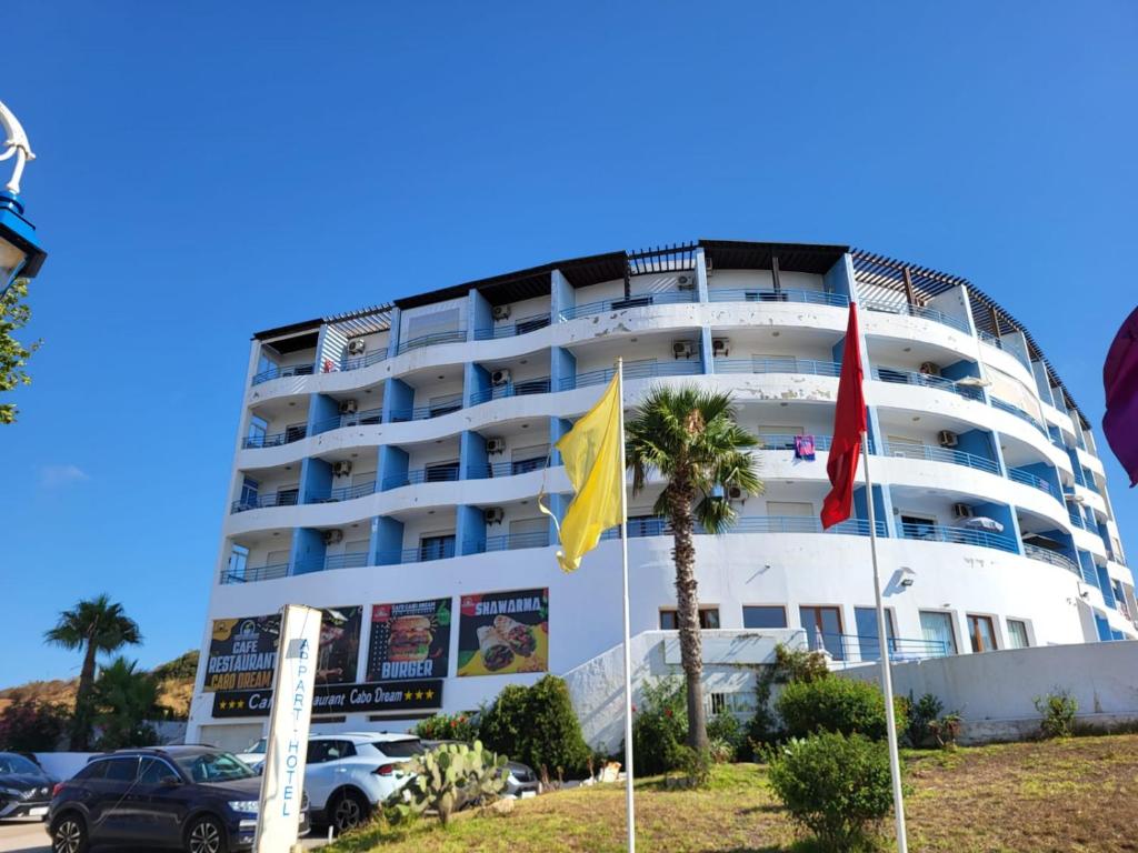 a large white building with flags in front of it at Cabo dream in Cabo Negro