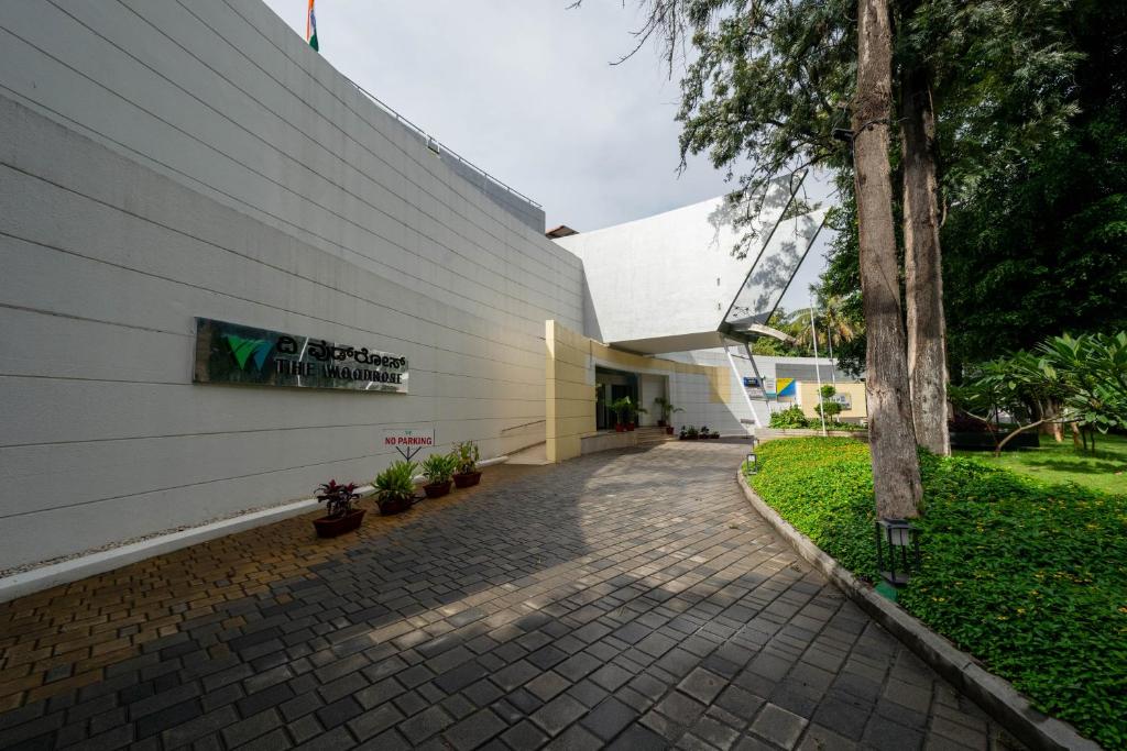 a building with a brick walkway next to a tree at THE WOODROSE in Bengaluru