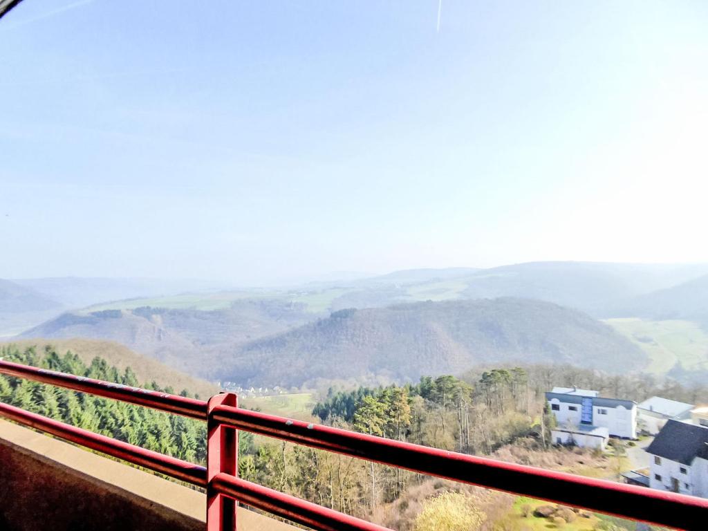 a view of the mountains from a red railing at Apartment Morgensonne B1105 by Interhome in Rhens
