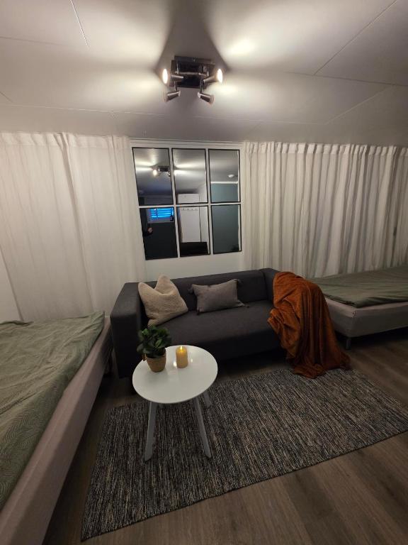 a living room with a couch and a table at Tromsdalen Studio 2 - FREE Parking, Views & Quiet Area in Trondalen