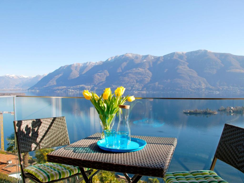 a table with a vase with flowers on it at Apartment Cà dal Non by Interhome in Ronco s/Ascona - Porto Ronco