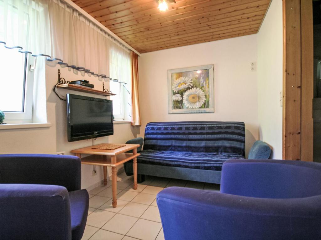 a living room with blue chairs and a tv at Apartment Apartment Kriasi by Interhome in Gortipohl