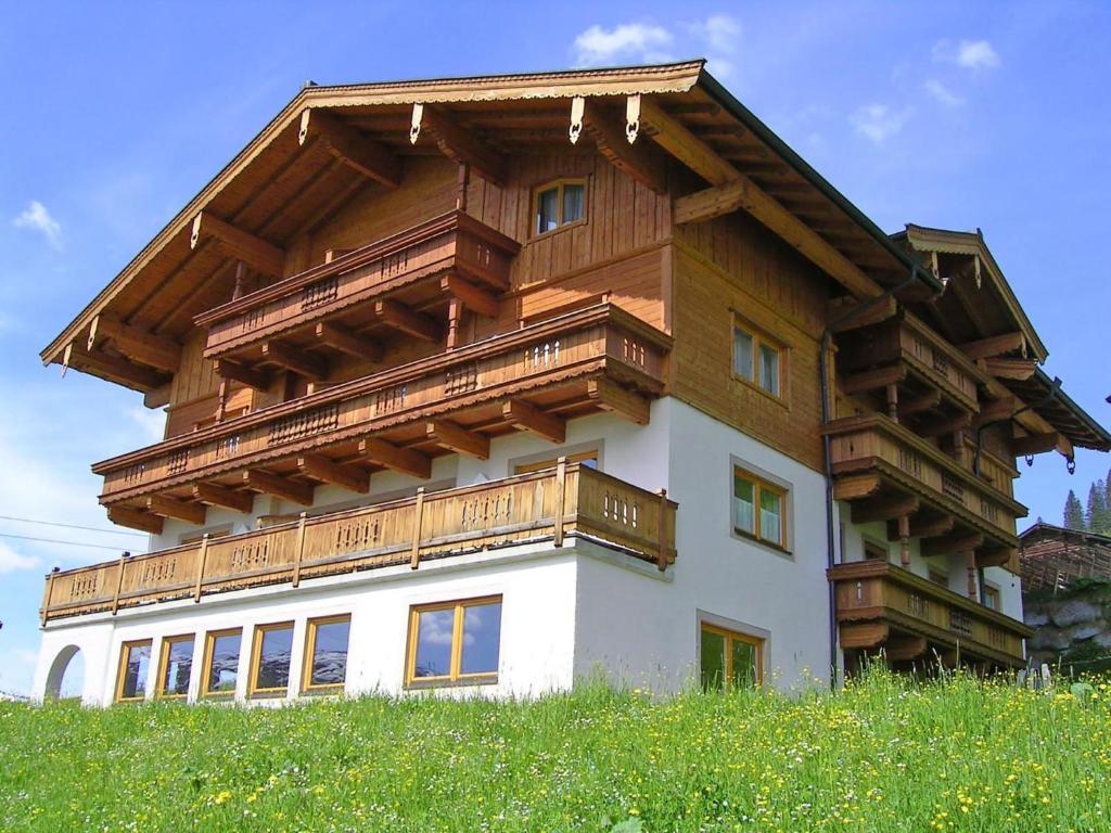 a house with wooden balconies on top of a hill at Apartment Voithofer-6 by Interhome in Königsleiten