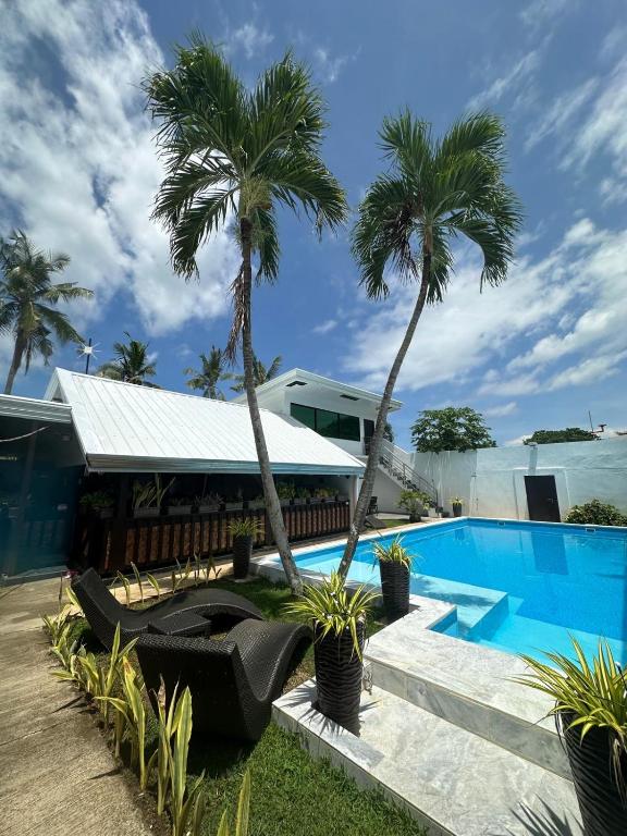 a resort with a swimming pool and palm trees at Jasmin Czechinn in Dauis