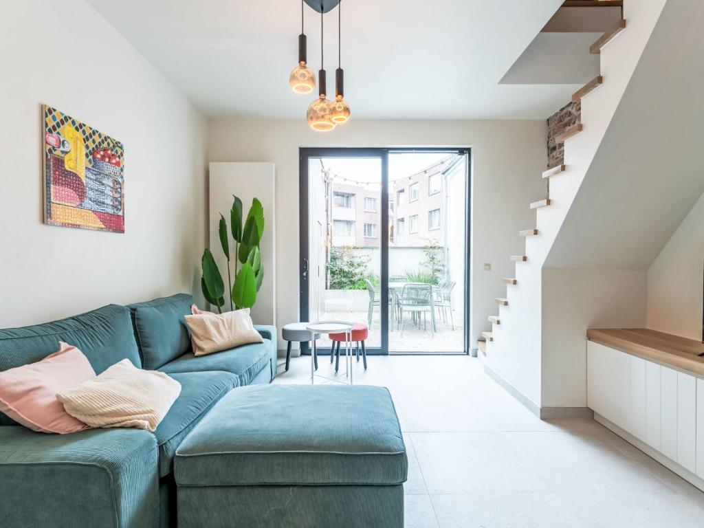 a living room with a blue couch and a table at Holiday Home Lili's with terrace by Interhome in Blankenberge