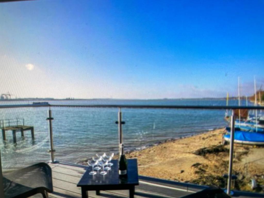 a view of a beach with a table and the water at Ten Admiralty Pier in Shotley Gate