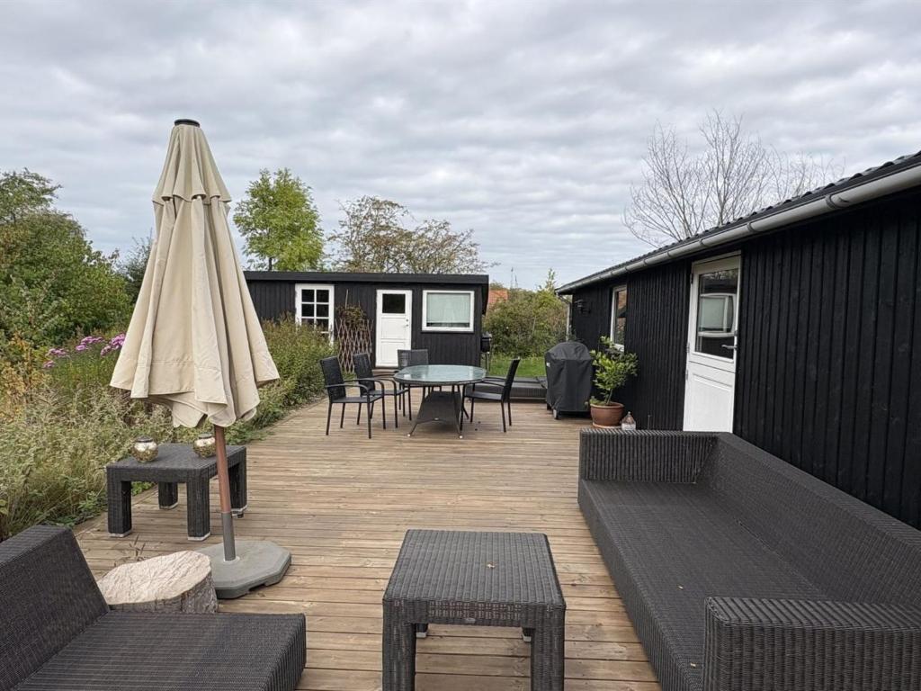 a patio with an umbrella and a table and chairs at Holiday Home Gun - 300m to the fjord by Interhome in Glostrup