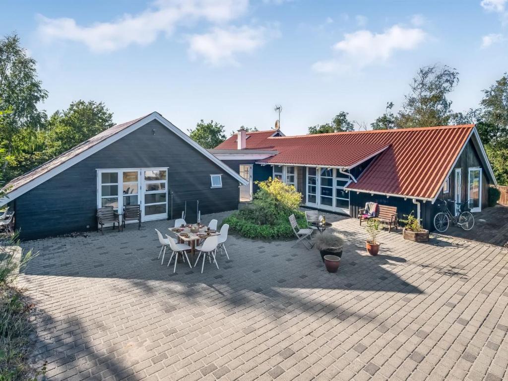 a house with a patio with a table and chairs at Holiday Home Tede - 1km from the sea by Interhome in Ebeltoft