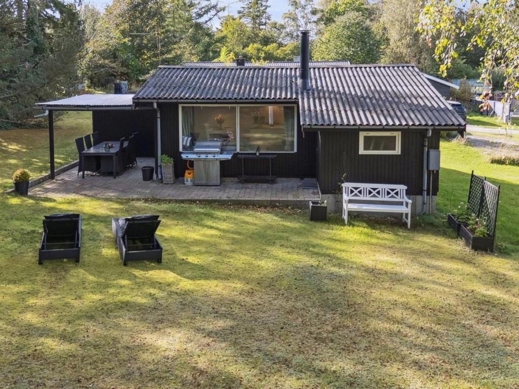 a small house with a table and chairs in a yard at Holiday Home Baarde - 1-2km from the sea by Interhome in Vejby