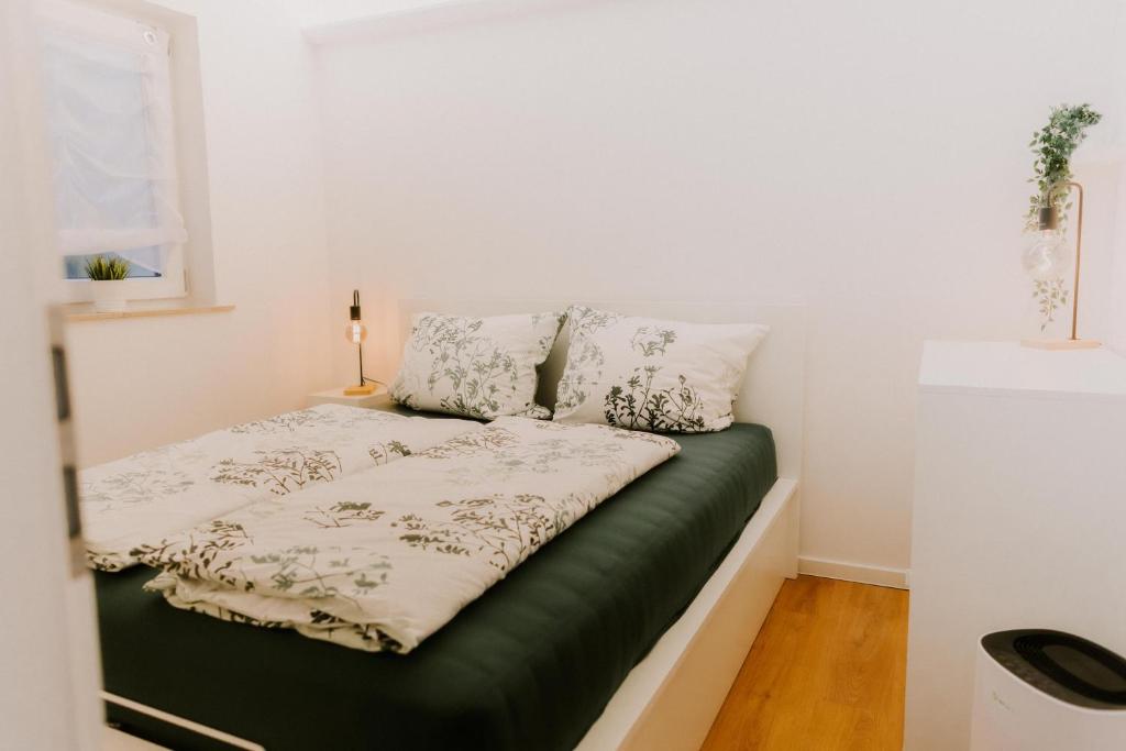 a small bedroom with a bed with a green mattress at Ferienwohnungen Bergnest Winterberg in Winterberg