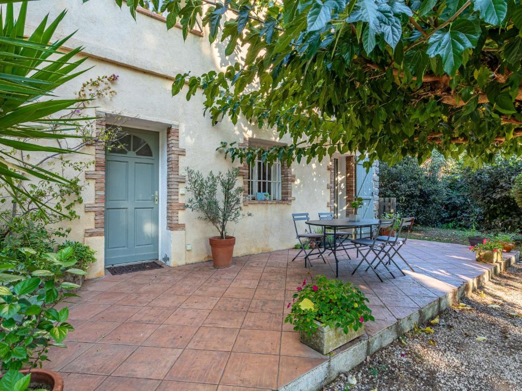 a patio with a table and chairs in front of a house at Villa Palmeraie by Interhome in Hyères