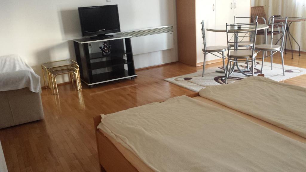 sala de estar con TV, mesa y sillas en ASP Apartments, en Ohrid