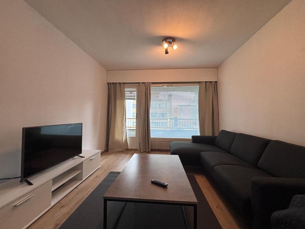 ein Wohnzimmer mit Couch und Flachbildfernseher in der Unterkunft Kotimaailma - Cozy and spacious apartment in Seinäjoki