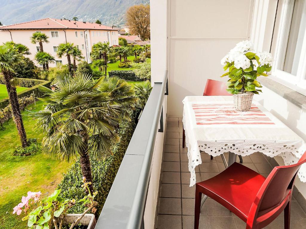 a balcony with a table and chairs and a palm tree at Apartment Junior Suite-7 by Interhome in Ascona