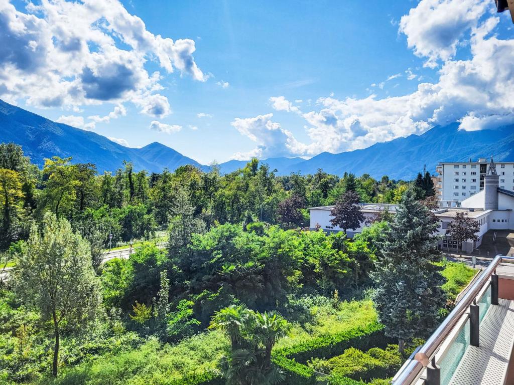 een balkon met uitzicht op een stad met bergen bij Apartment Apt-Green View by Interhome in Locarno
