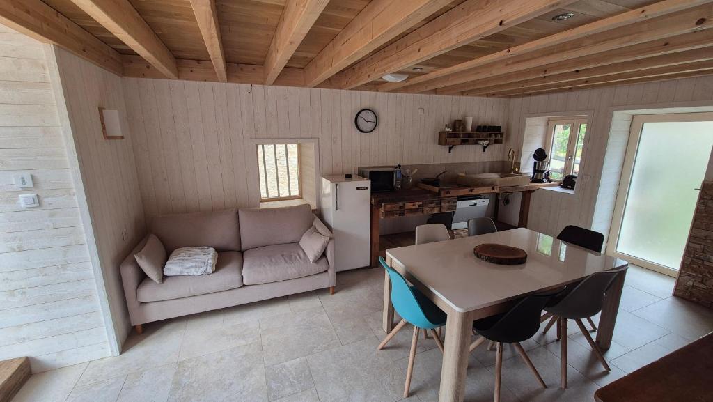 FourbanneにあるLa cabane du pédaleurのキッチンとテーブルとソファのあるリビングルーム