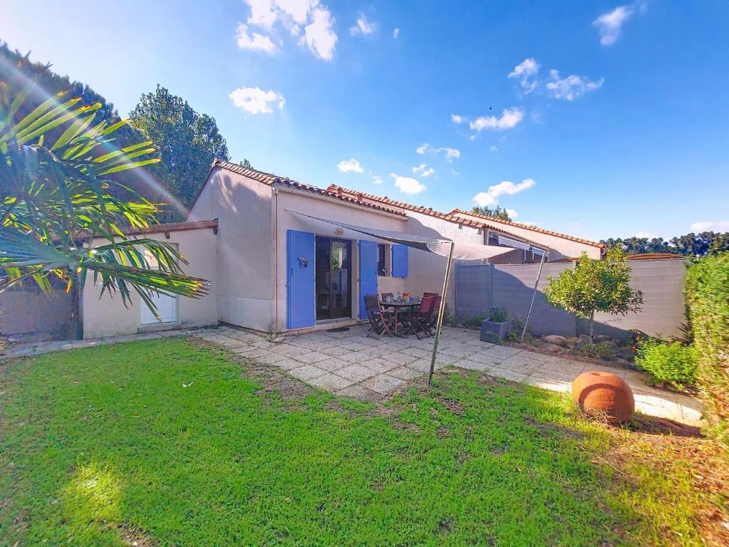 a small white house with a yard at Holiday Home Les Charmilles-16 by Interhome in La Palmyre