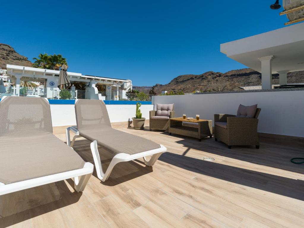 a patio with lounge chairs and a pool at Marina nº 296 in Puerto de Mogán