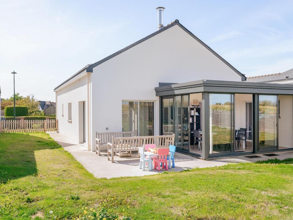 a house with glass doors and a table and a bench at Holiday Home Bol d'Air by Interhome in Ploubalay