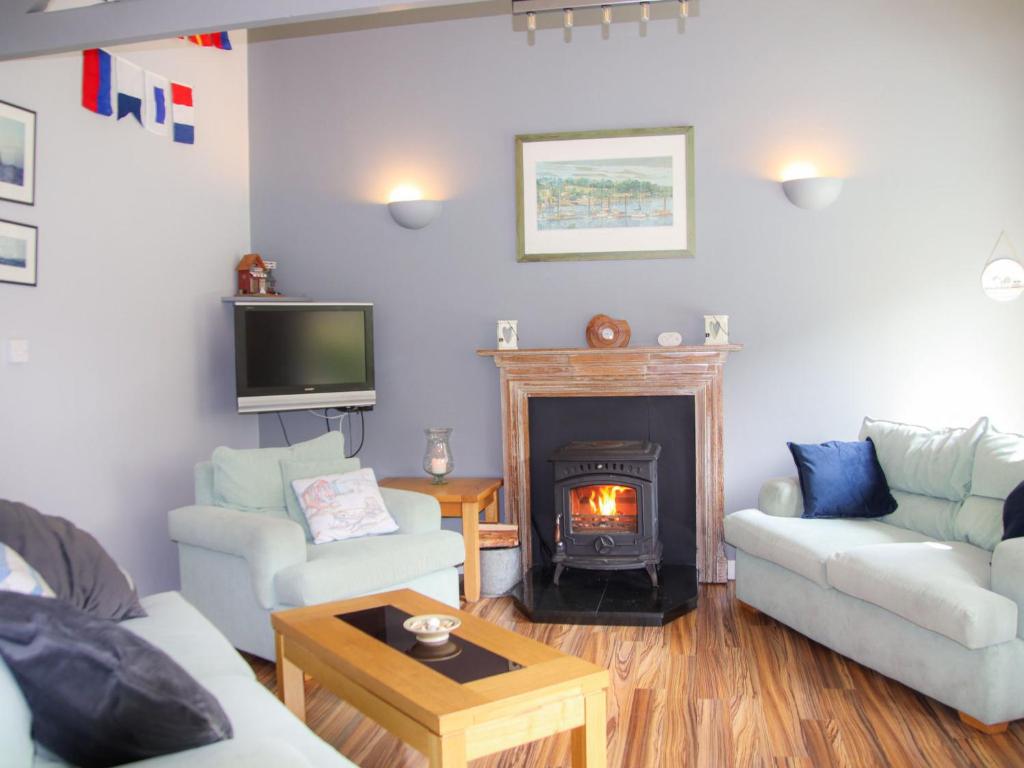 Una sala de estar con un sofá y una chimenea. en Holiday Home Dunmore Villas Holiday Home No 1 by Interhome, en Dunmore East