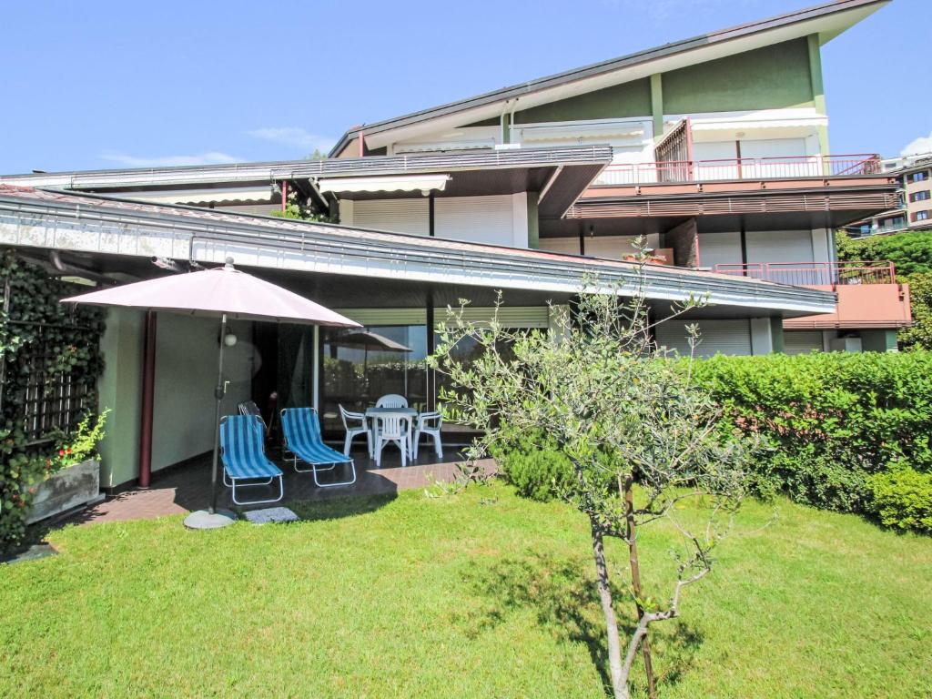 a house with two chairs and an umbrella at Studio B116 by Interhome in Cissano