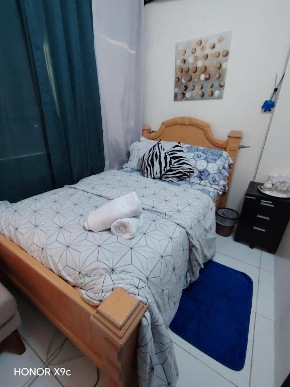 a small bedroom with a bed with a zebra pillow at The Cozy Home in Abu Dhabi