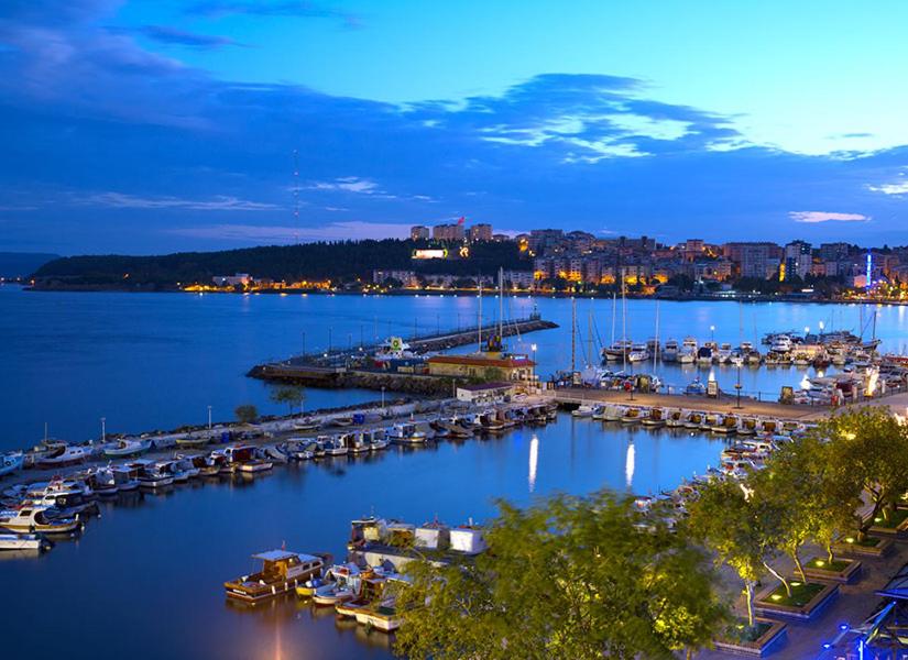 a marina with boats in the water at night at Kinzi House in Canakkale