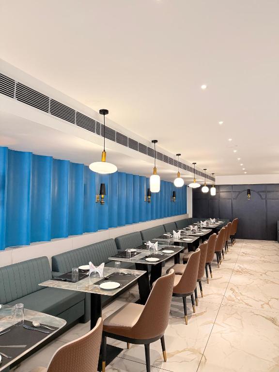 a dining room with long tables and chairs at Hotel Roop Cliff, Bhopal in Bhopal
