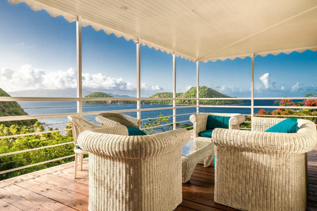 a porch with chairs and a view of the ocean at Villa Secrète du Pain de Sucre in Terre-de-Haut