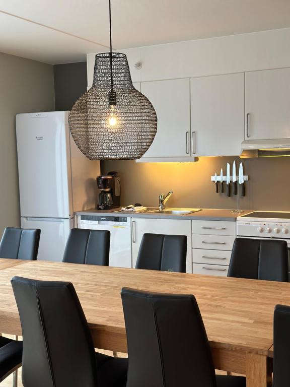 a kitchen with a wooden table and black chairs at Kongsberg Booking in Kongsberg