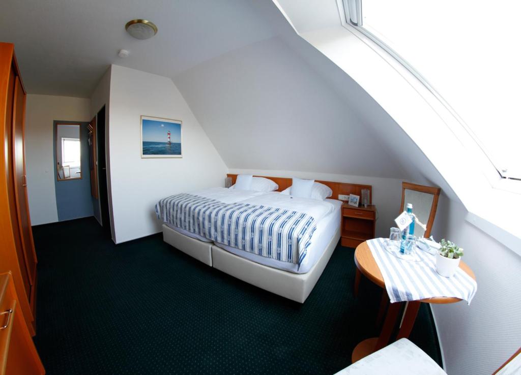 ein Hotelzimmer mit einem Bett und einem Tisch in der Unterkunft ankerplatz-Hotel garni in Wilhelmshaven