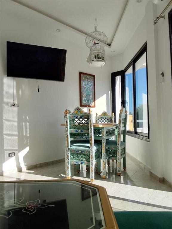 Cette chambre dispose de 2 chaises, d'une table et d'une télévision. dans l'établissement Dar houriya, à Tabarka