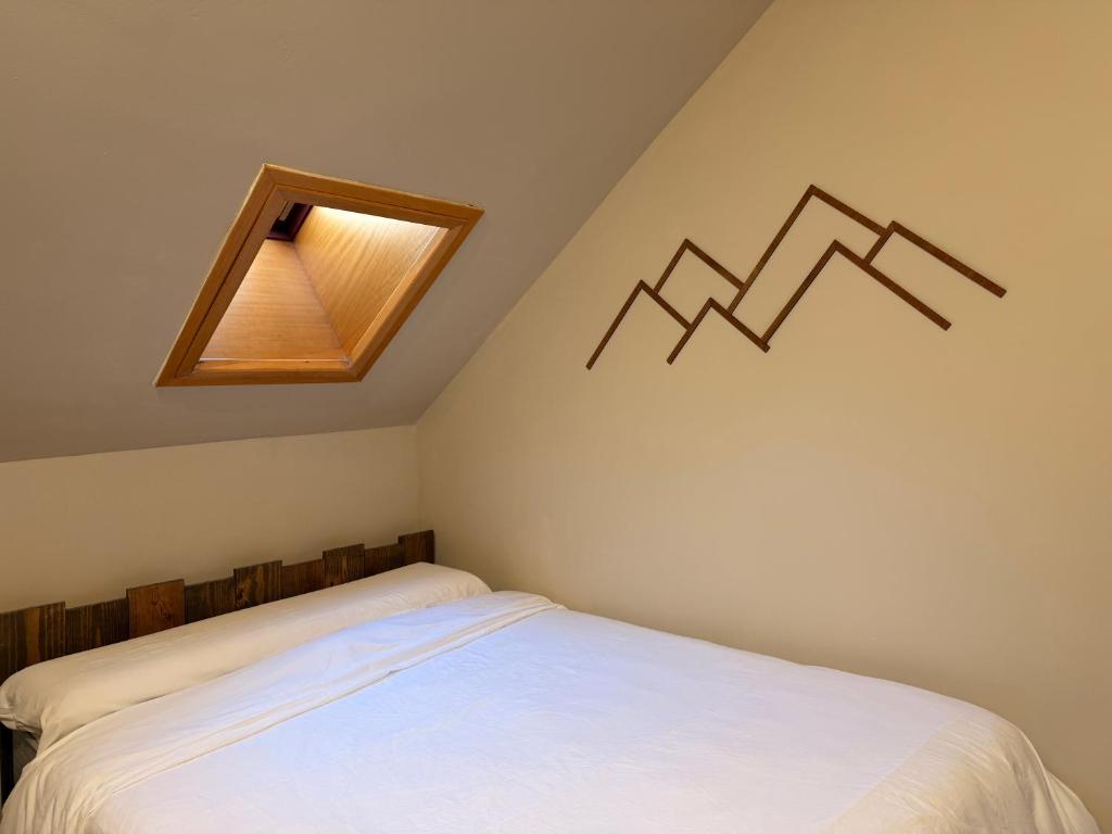 a small bedroom with a bed with a skylight at Acogedor Ático en el Corazón de Formigal - Esquía sin llaves in Formigal