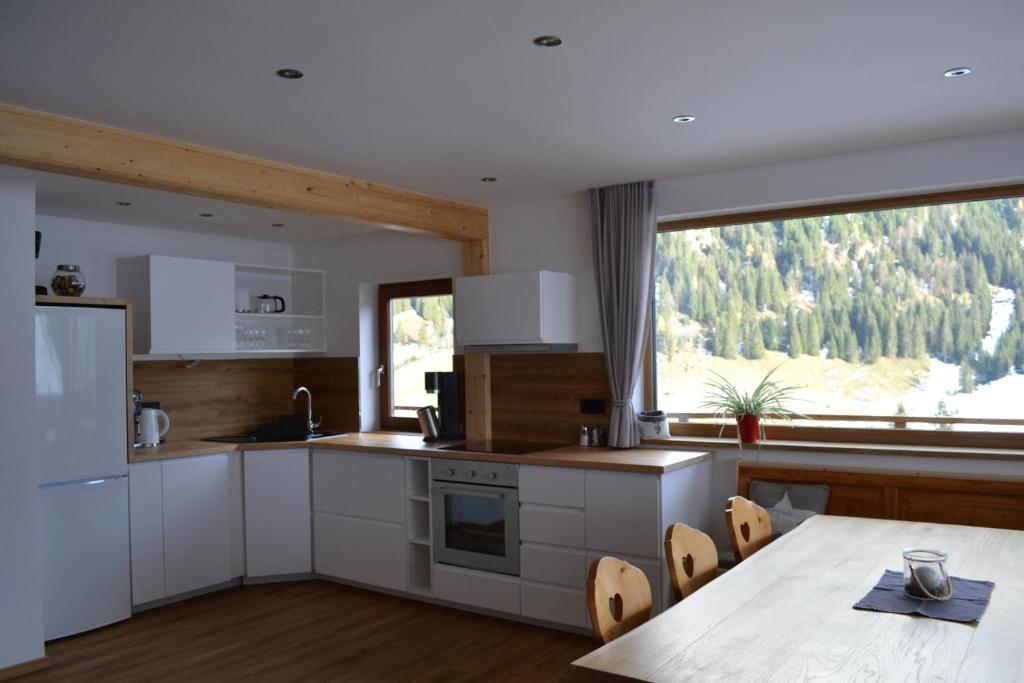 a kitchen with a table and a large window at FamilienAppartement Waldstüberl in Kleinarl
