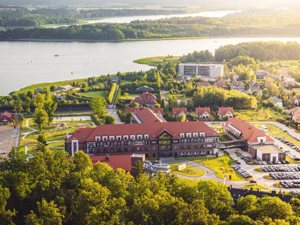 an aerial view of a building with a lake in the background at Radisson Blu Resort & Conference Center, Ostróda Mazury in Ostróda