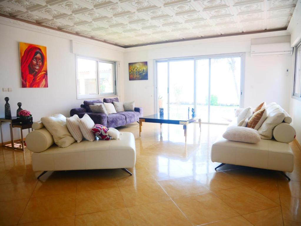 a living room with two couches and a table at Oasis luxueuse en bord de Mer Virage Dakar in Dakar
