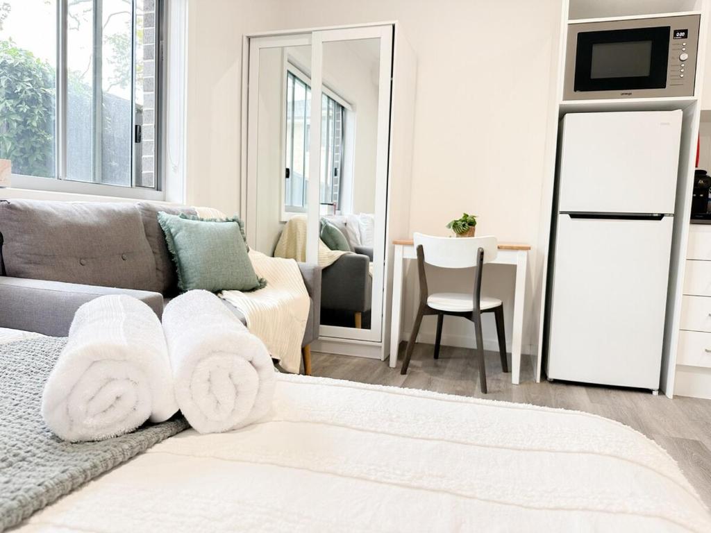a living room with a couch and a table at North Wollongong - Beach Style - Modern - Free Parking - Free Coffee Snacks in Woonona