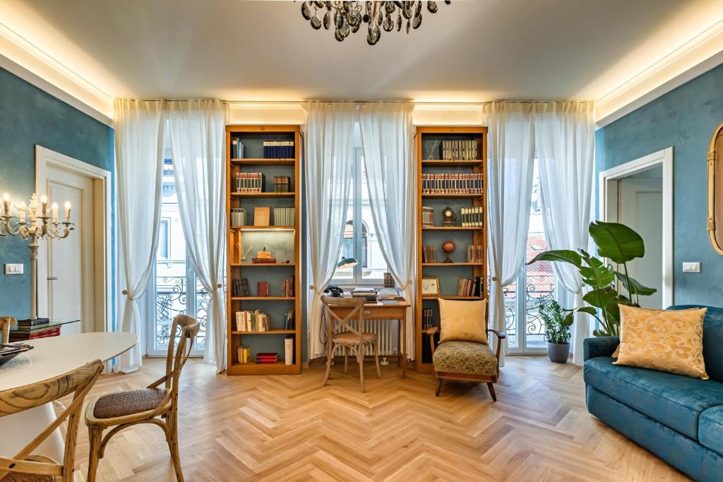 a living room with a blue couch and a table at Casa Saba Trieste Luxury Apartment with terrace in Trieste