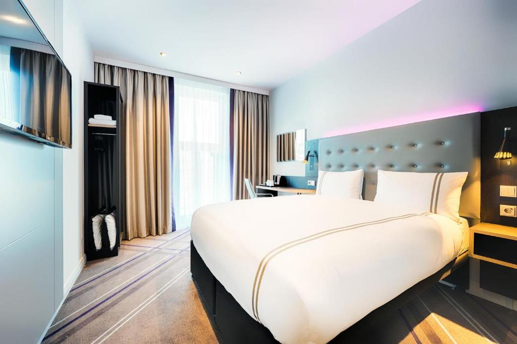 a hotel room with a large bed and a desk at Premier Inn Dresden City Prager Straße in Dresden