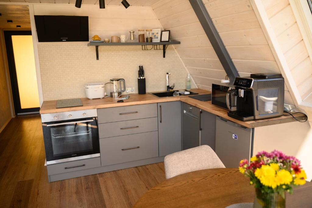 a kitchen with stainless steel appliances and a wooden floor at Дім у Карпатах in Rechka